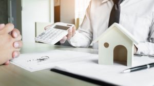Real estate agent showing the purchase price on a calculator to his client